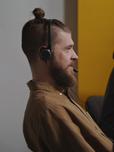 Crisis Hotline employee wearing a headset and leaning back in the chair while talking to a caller.