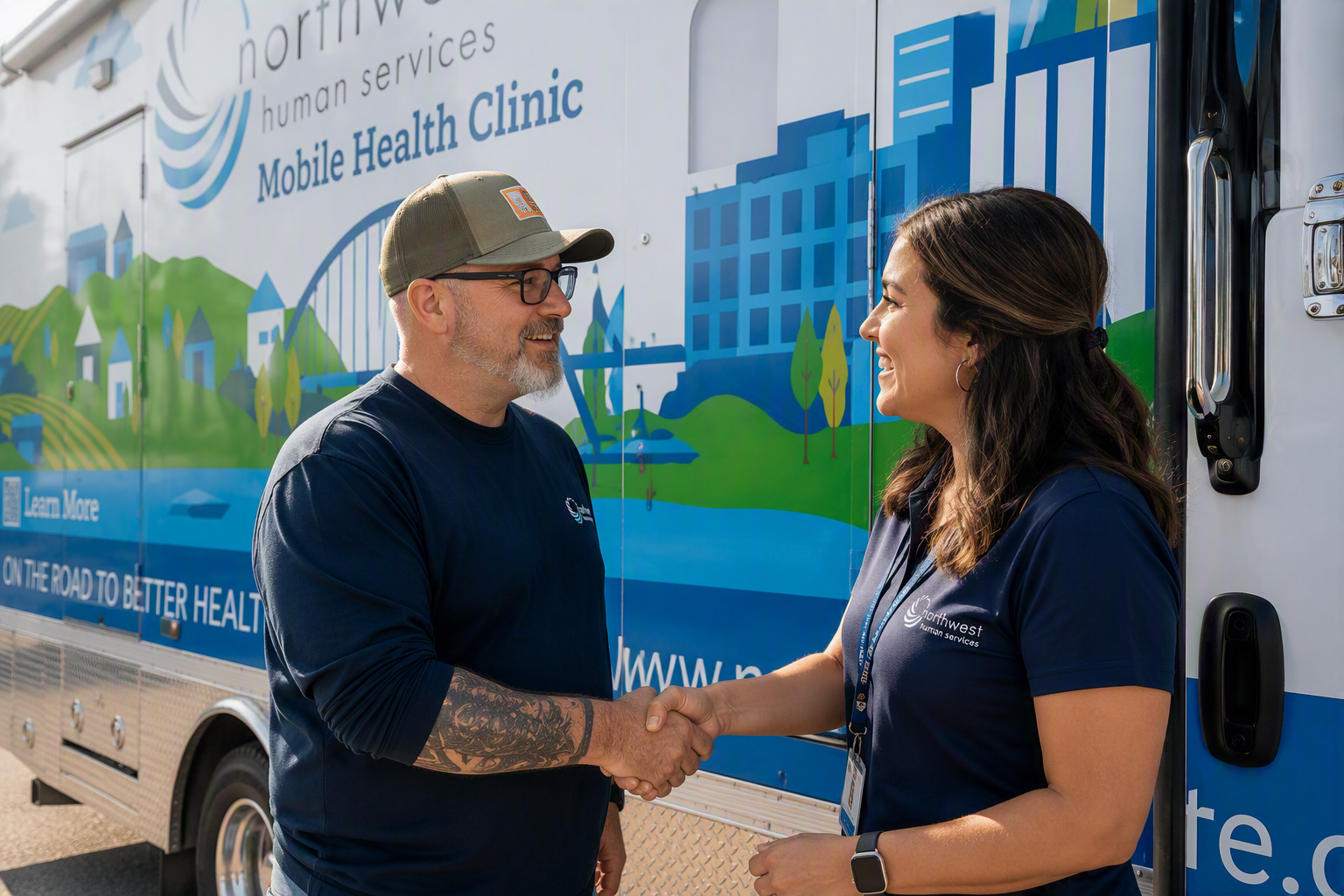 Community business partner and Northwest Human Services representative shaking hands beside the Mobile Health Clinic to support healthcare access in Polk County.